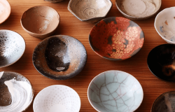 Variety of colorful "ochoko" sipping cups on a wooden surface.