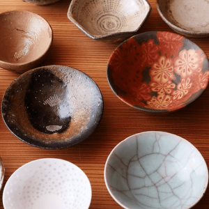 Variety of colorful "ochoko" sipping cups on a wooden surface.